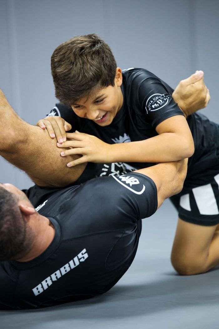 A young jiu-jitsu student focused during a kids class drill